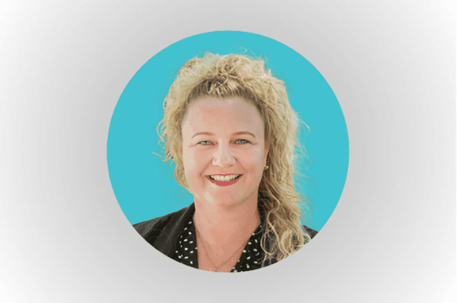 Headshot of a smiling woman with curly hair against a blue background.